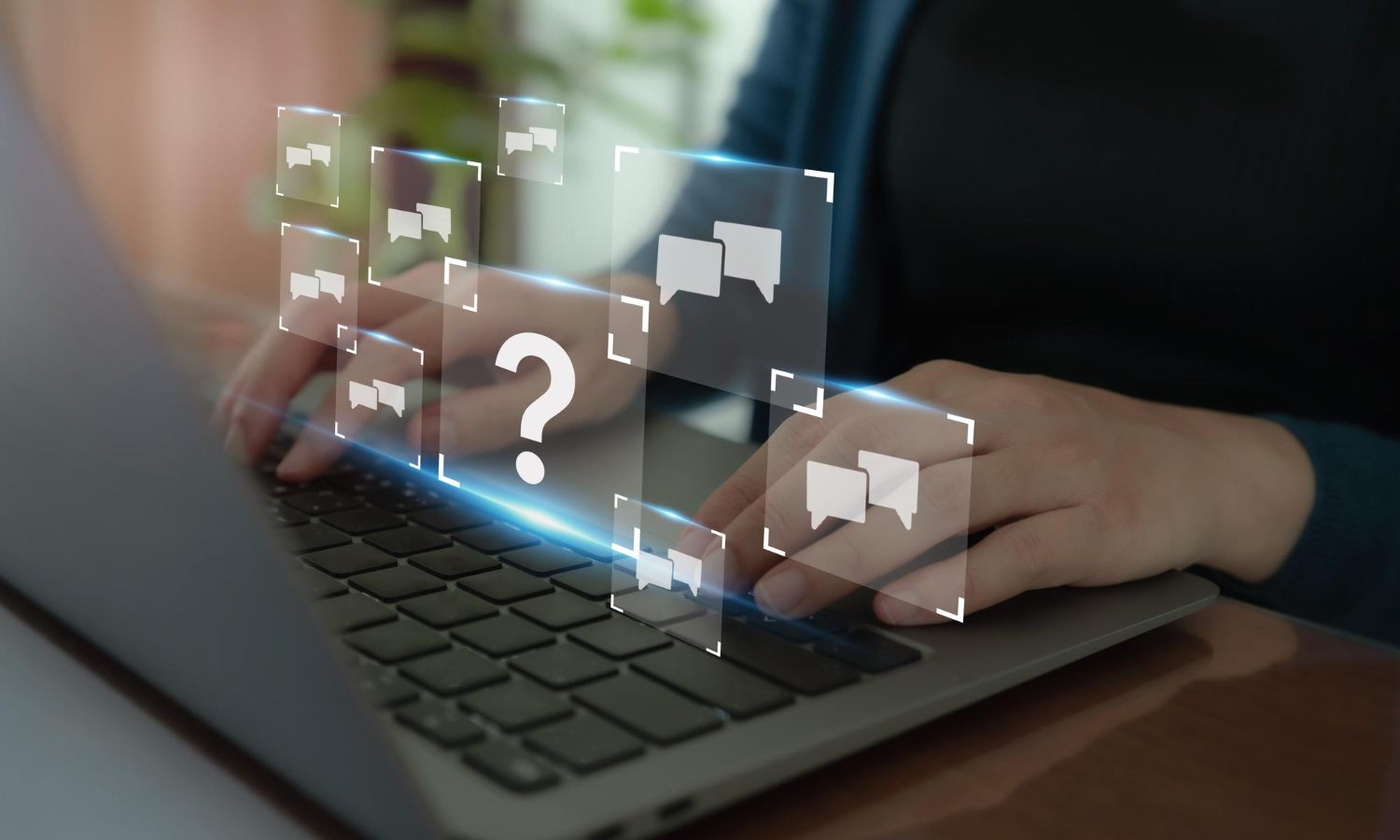 Person using a laptop with digital question and conversation symbols